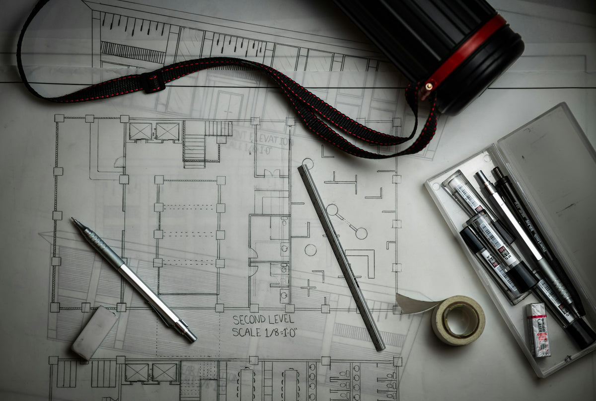 Architectural drawings and drafting tools on a desk